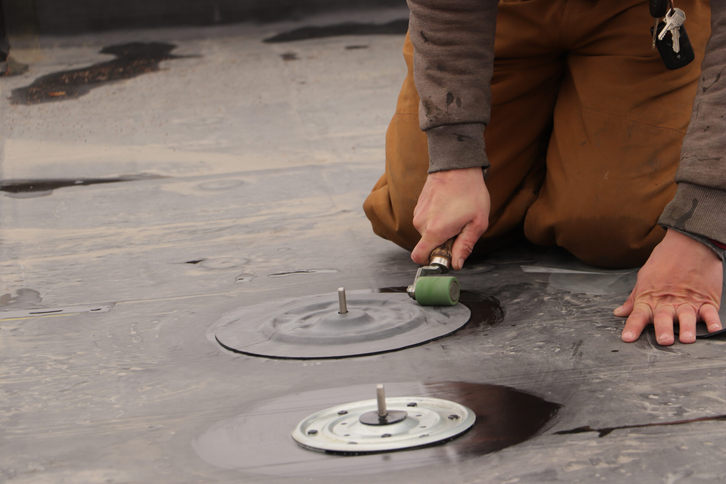 Installing a solar foot on a fully-adhered EPDM roof.