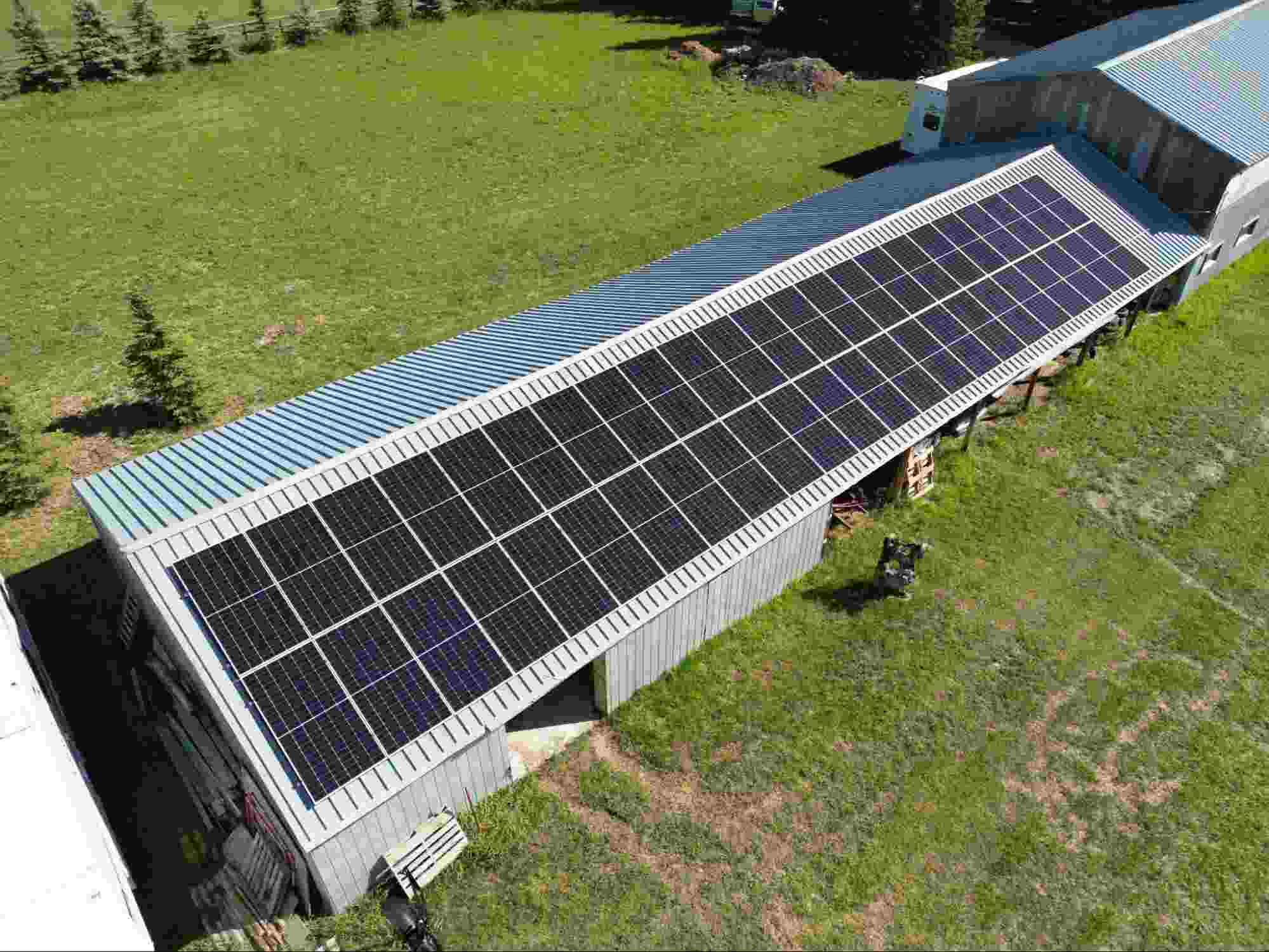 Best solar company Alberta installing rooftop solar panels on a rural agricultural building for efficient renewable energy production.