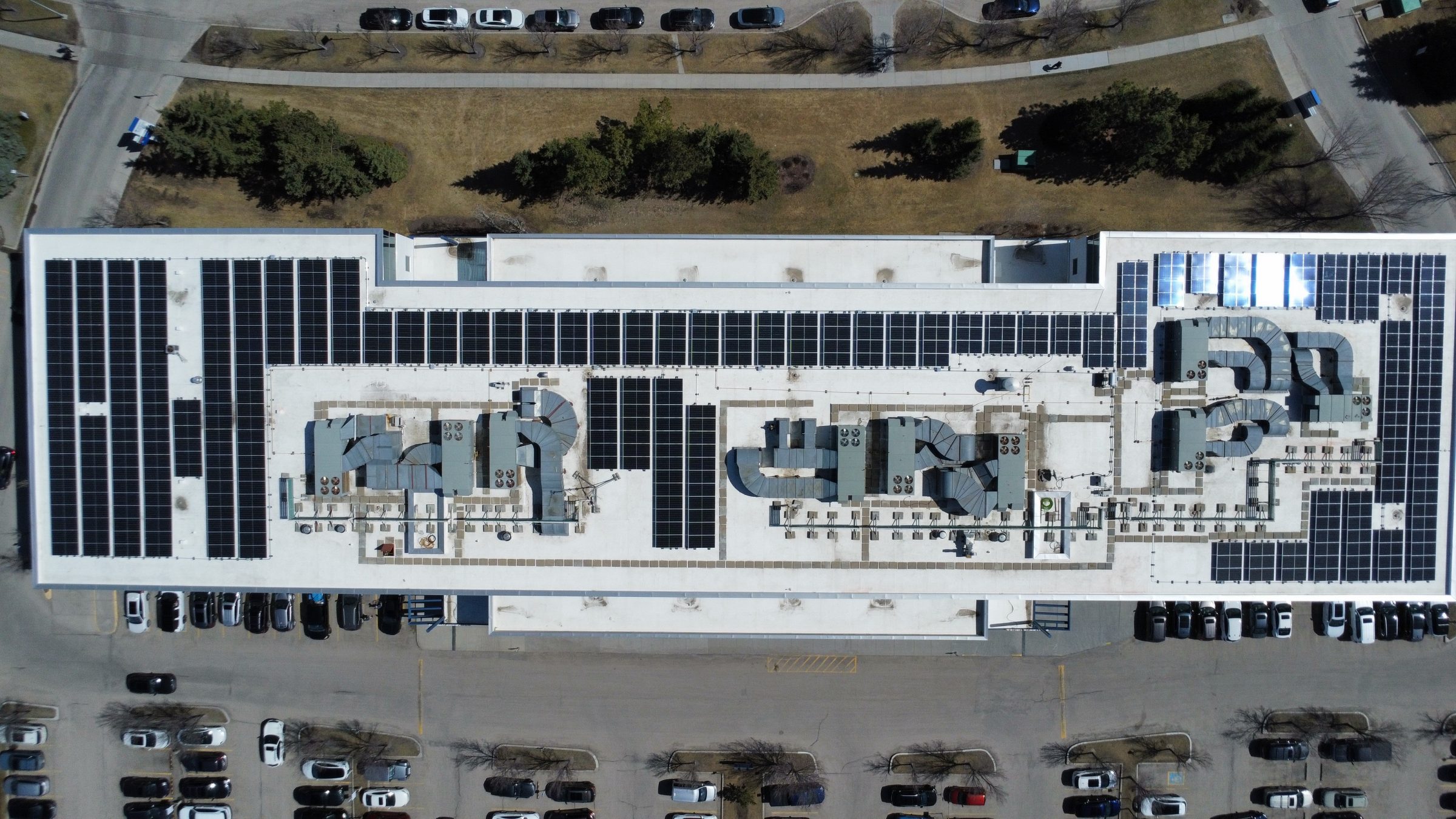 Aerial view of a 240 kW DC commercial solar array in SE Calgary integrated with a full building re-roof