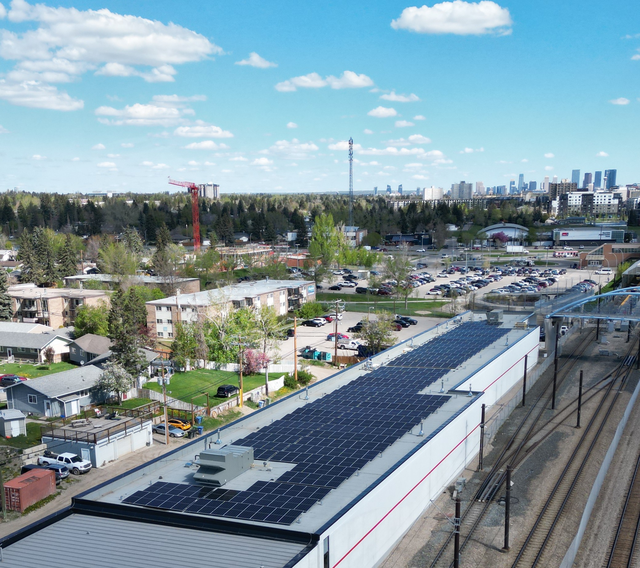 Aerial view of a sprawling commercial solar panel installation on a flat-roof office building in Calgary.